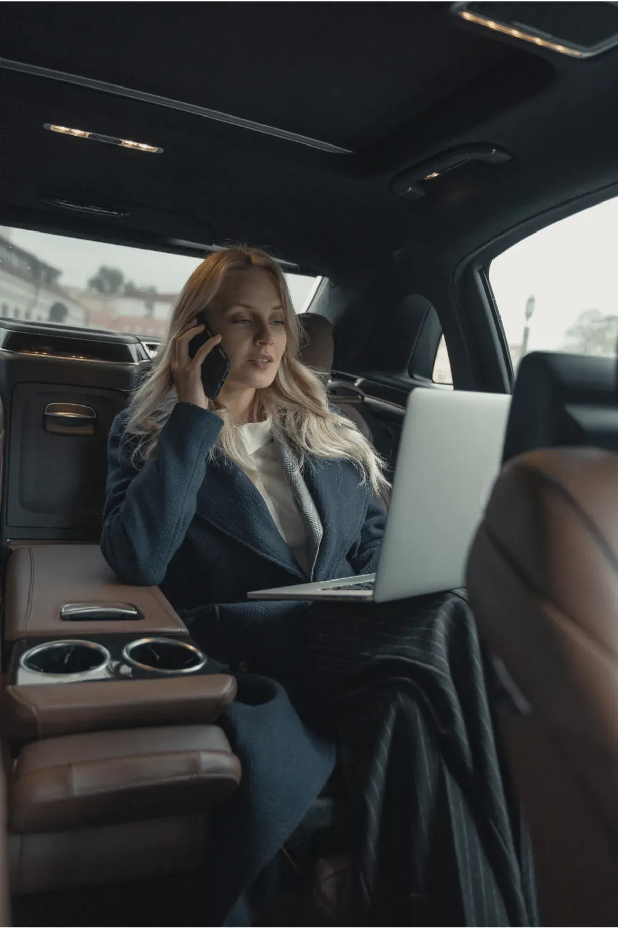 Business traveler in the back of a premium chauffeured car